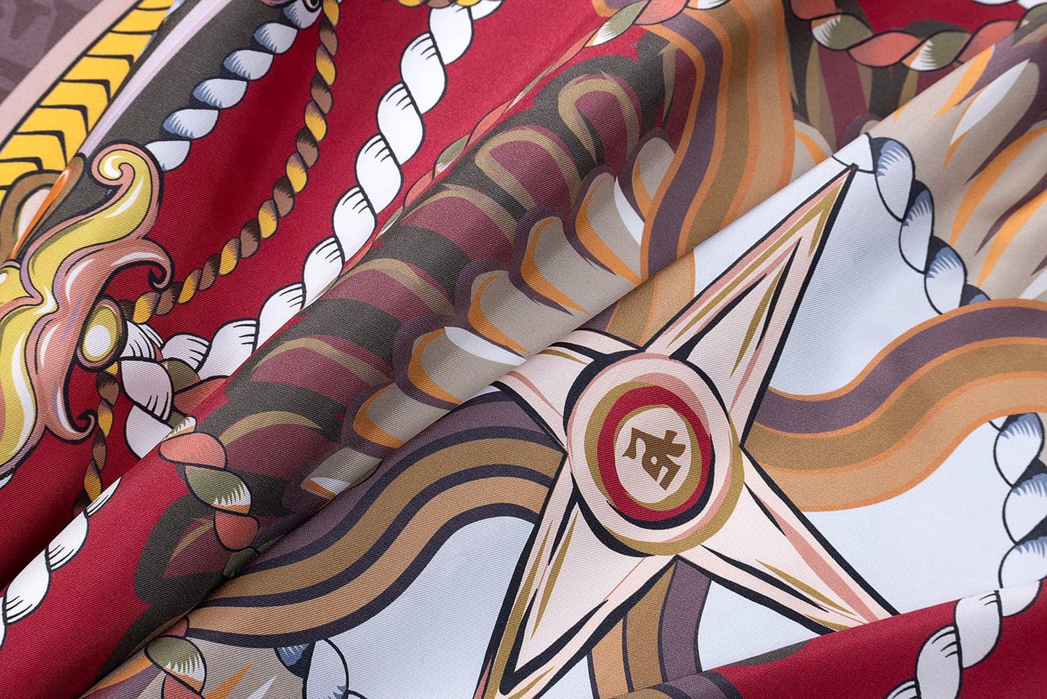 Macro detail of a Tawalap heritage scarf, silk folded to reveal the rope and rosette print