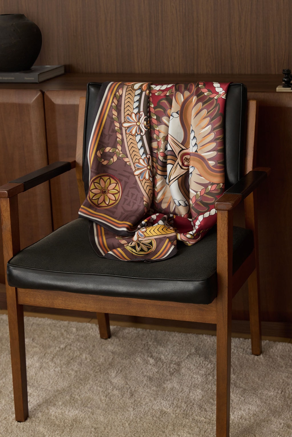 Tawalap heritage scarf, hanging against dark wood chair.